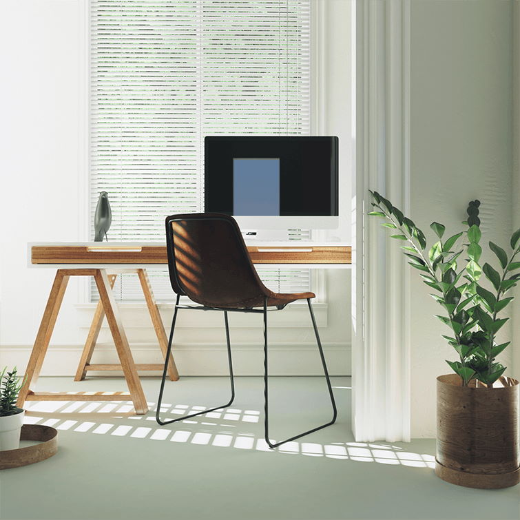an image of a home office set up with chair next to table with computer on top of it next to bright windows 