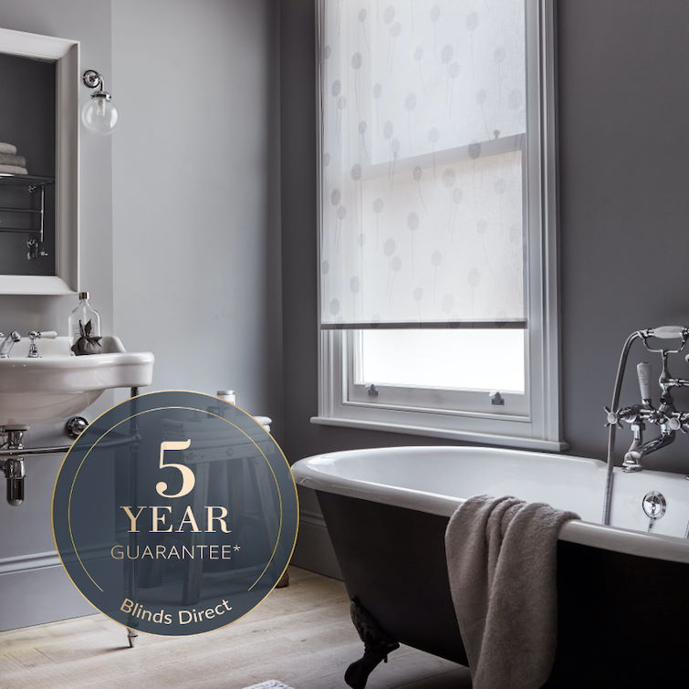 photo of dark grey bathroom with large bath tub next to window