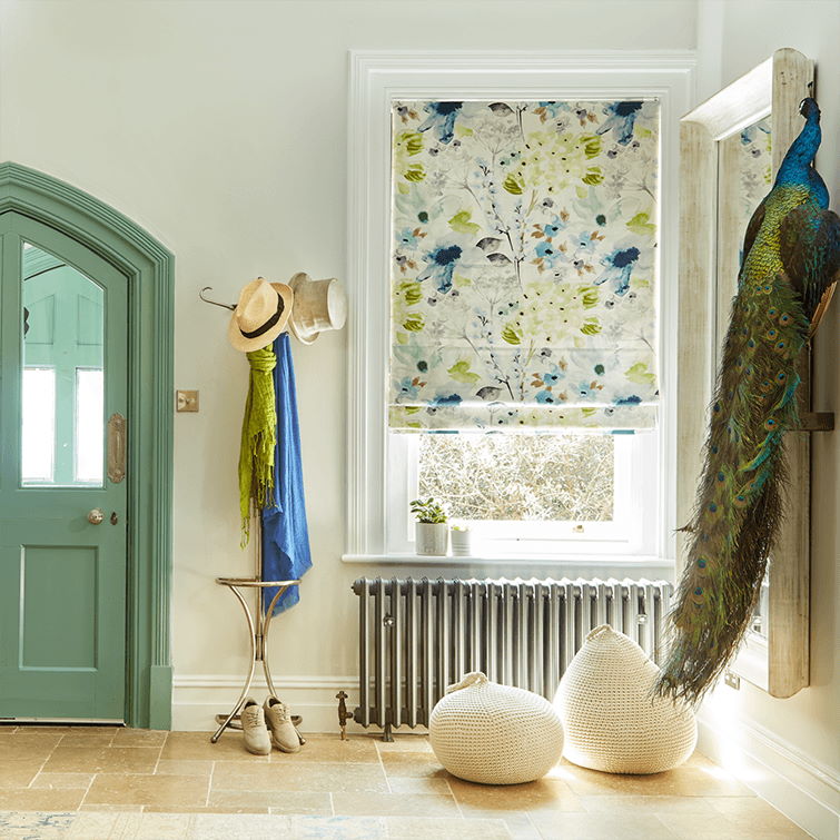 image of hallway styled with different shades of green with large window above grey radiator