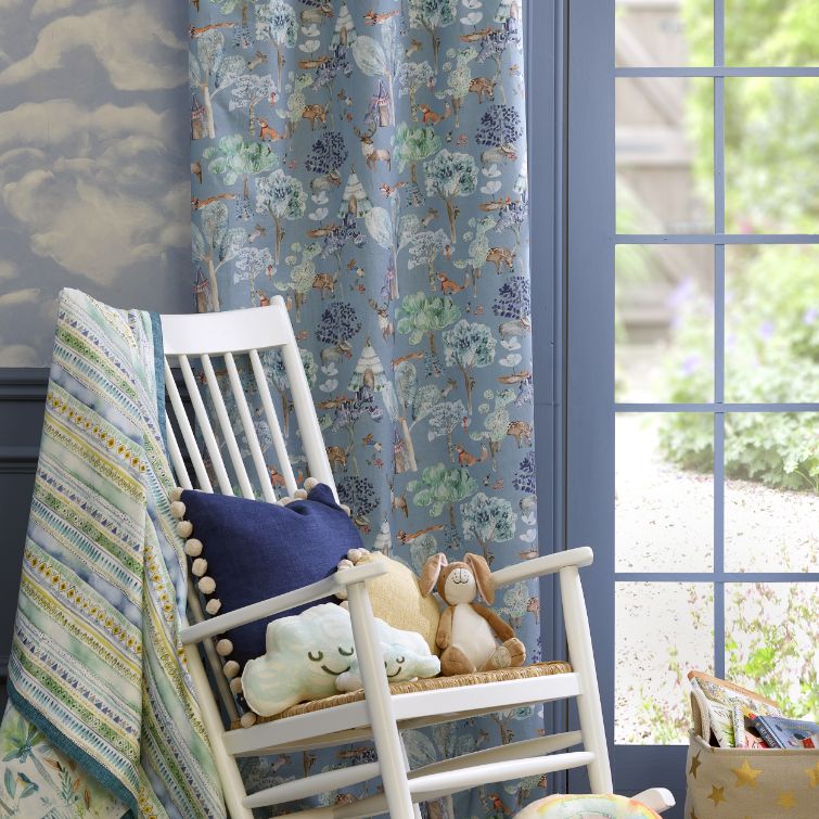 image of white wooden wooden chair with cushion and toys on it next to window with children's curtains fitted