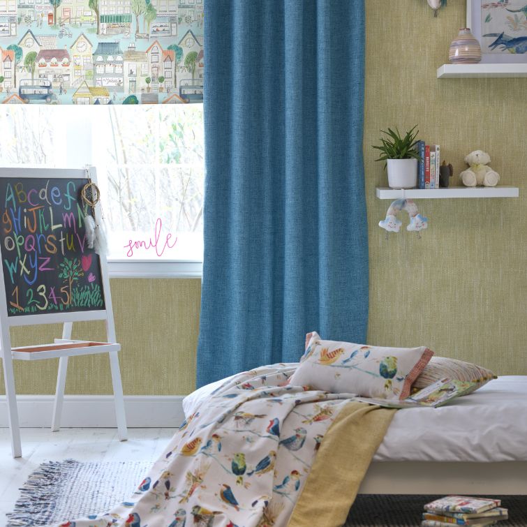 photo of children's room with bed next to a chalk board and window and blue curtains 