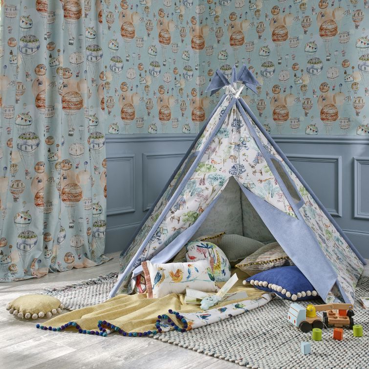 image of a den in a kids room next to a children's curtains with pattern that matches the wall