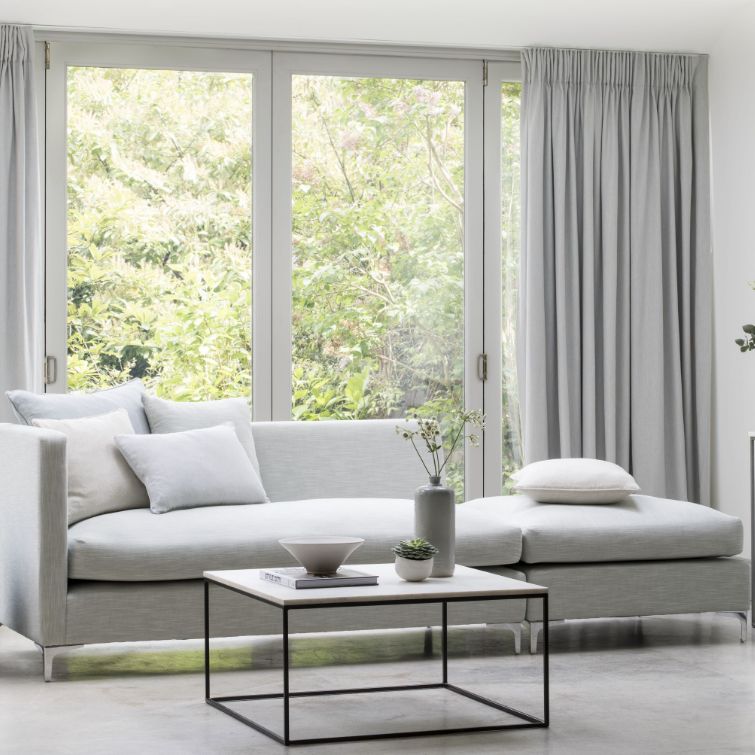image of grey themed room with sofa infront of large window with eyelet curtains fitted 