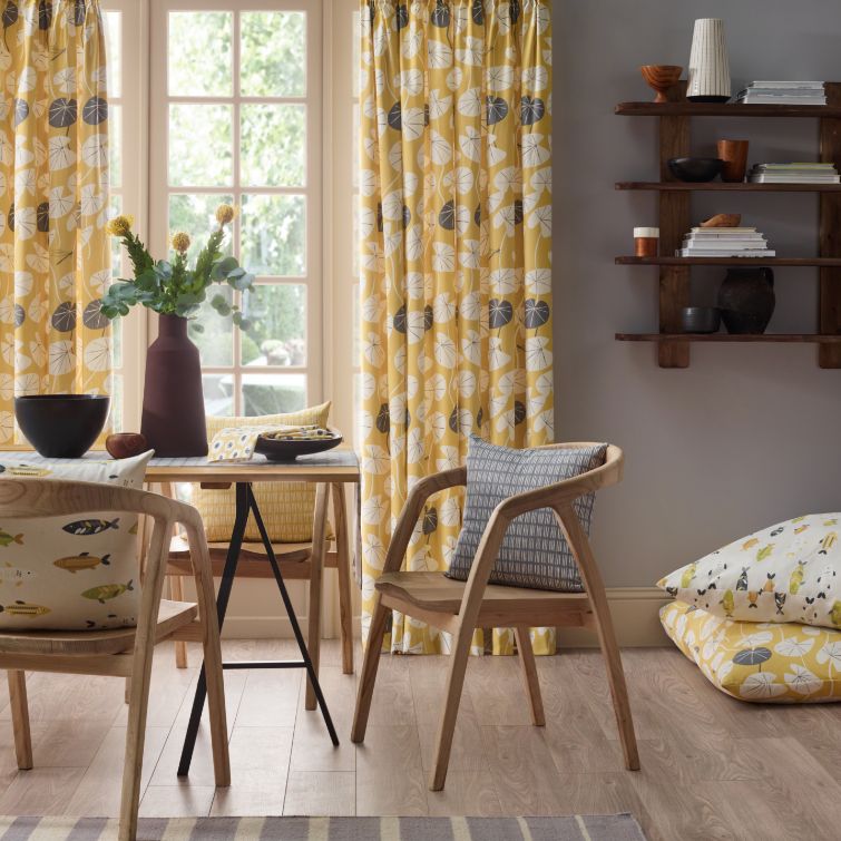 image of grey and yellow kitchen using pinch pleat curtains as a window dressing 
