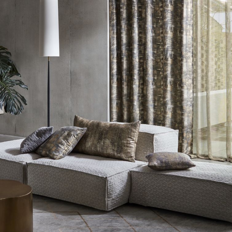 image of grey sofa with cushions on it infront of large window with wave curtains