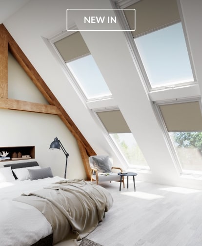 Blinds for Velux windows in an attic bedroom with sloped ceilings and a cozy bed