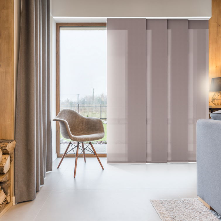 image of brown chair in the corner of a room next to floor to ceiling window